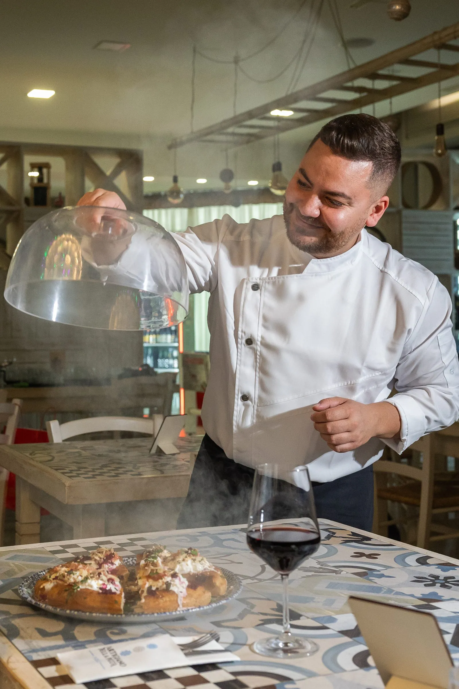 Matteo Toma solleva la cloche su una pizza in sala