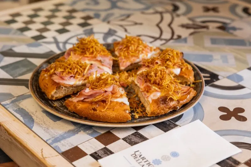 Pizza a spicchi sul tavolo di maioliche
