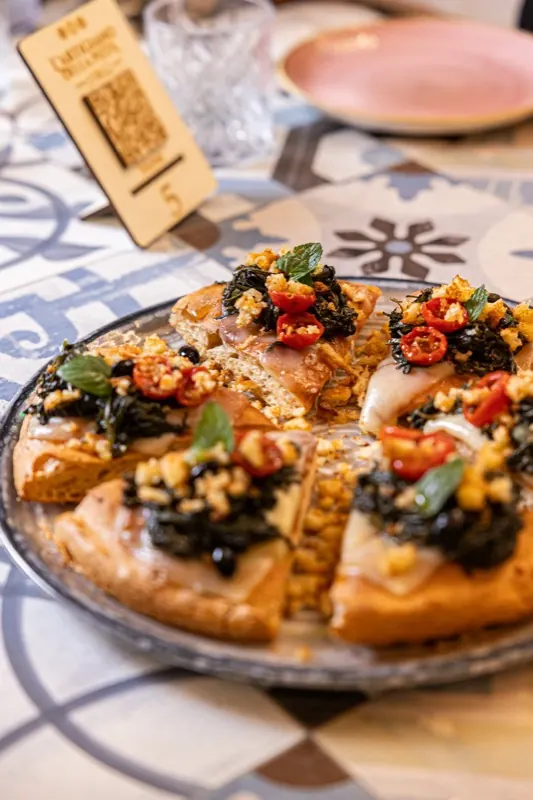 Pizza con cime di rapa servita al tavolo