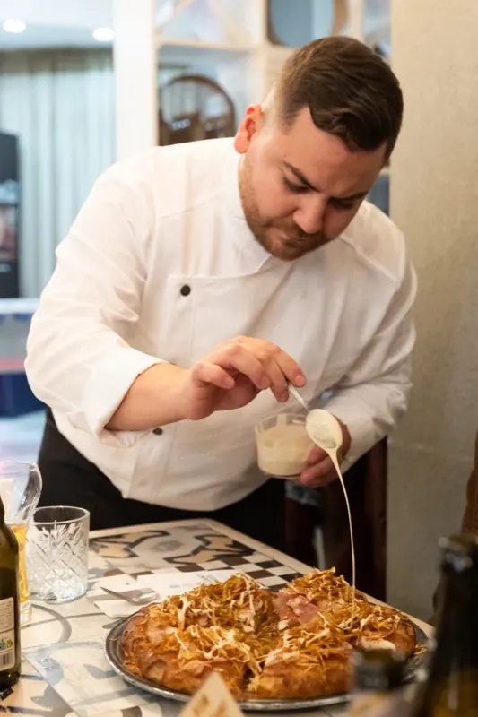 Matteo Toma rifinisce un piatto con la salsa