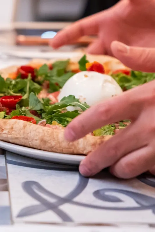 Pizza con burrata tenuta tra le mani