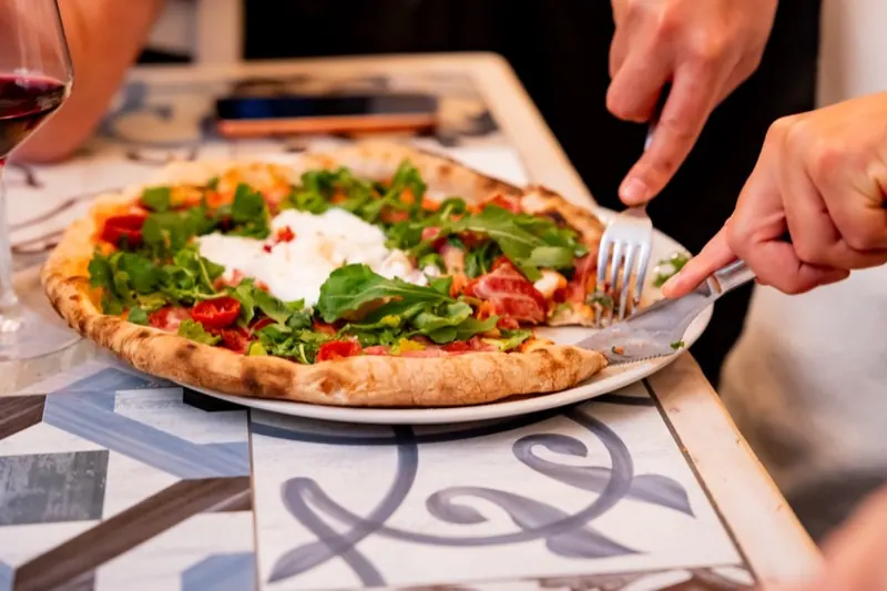 Taglio della pizza con burrata